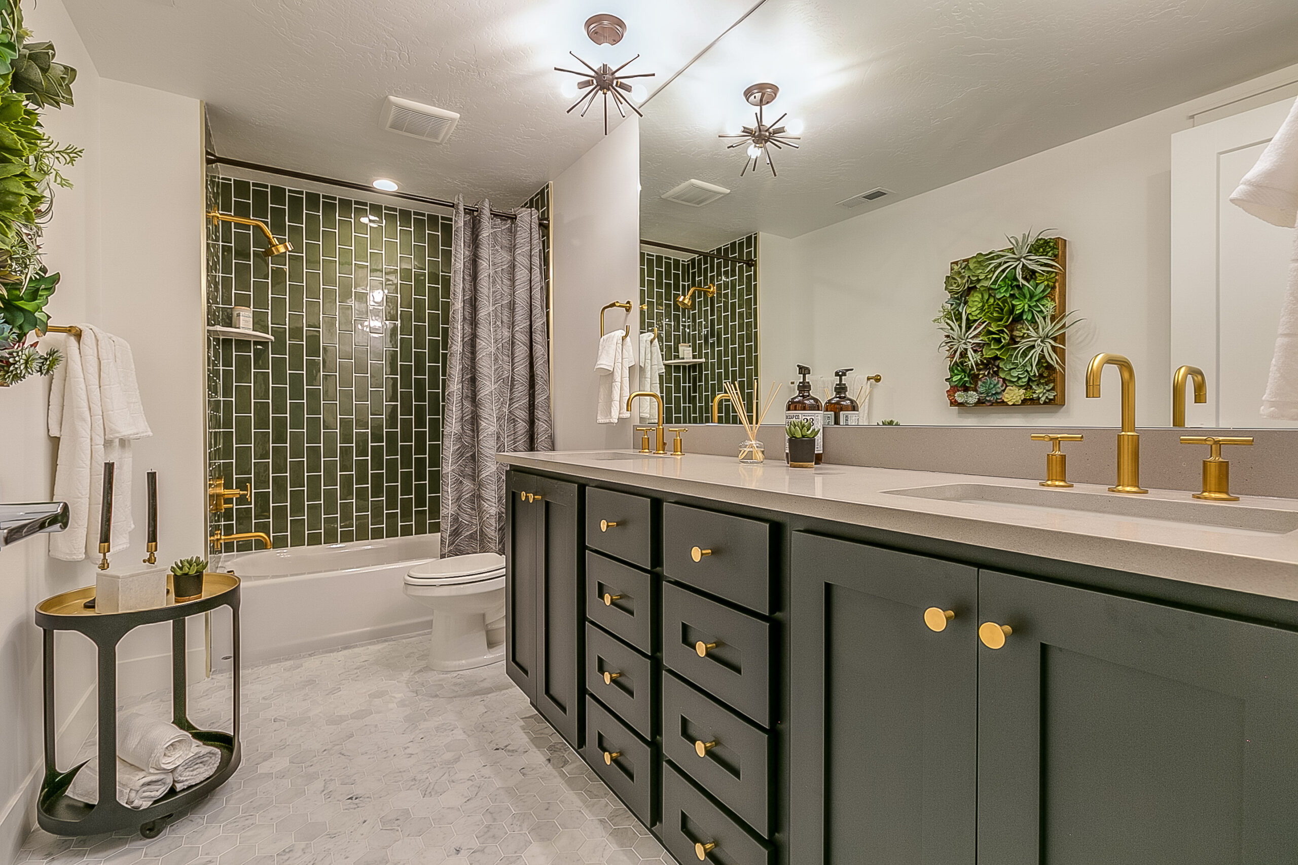 Green is the theme in this beautiful bathroom with brass faucets and fixtures